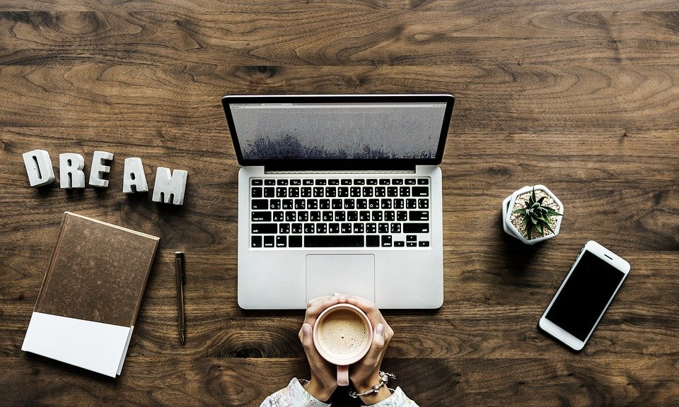 blogger sitting in front of a laptop with coffee